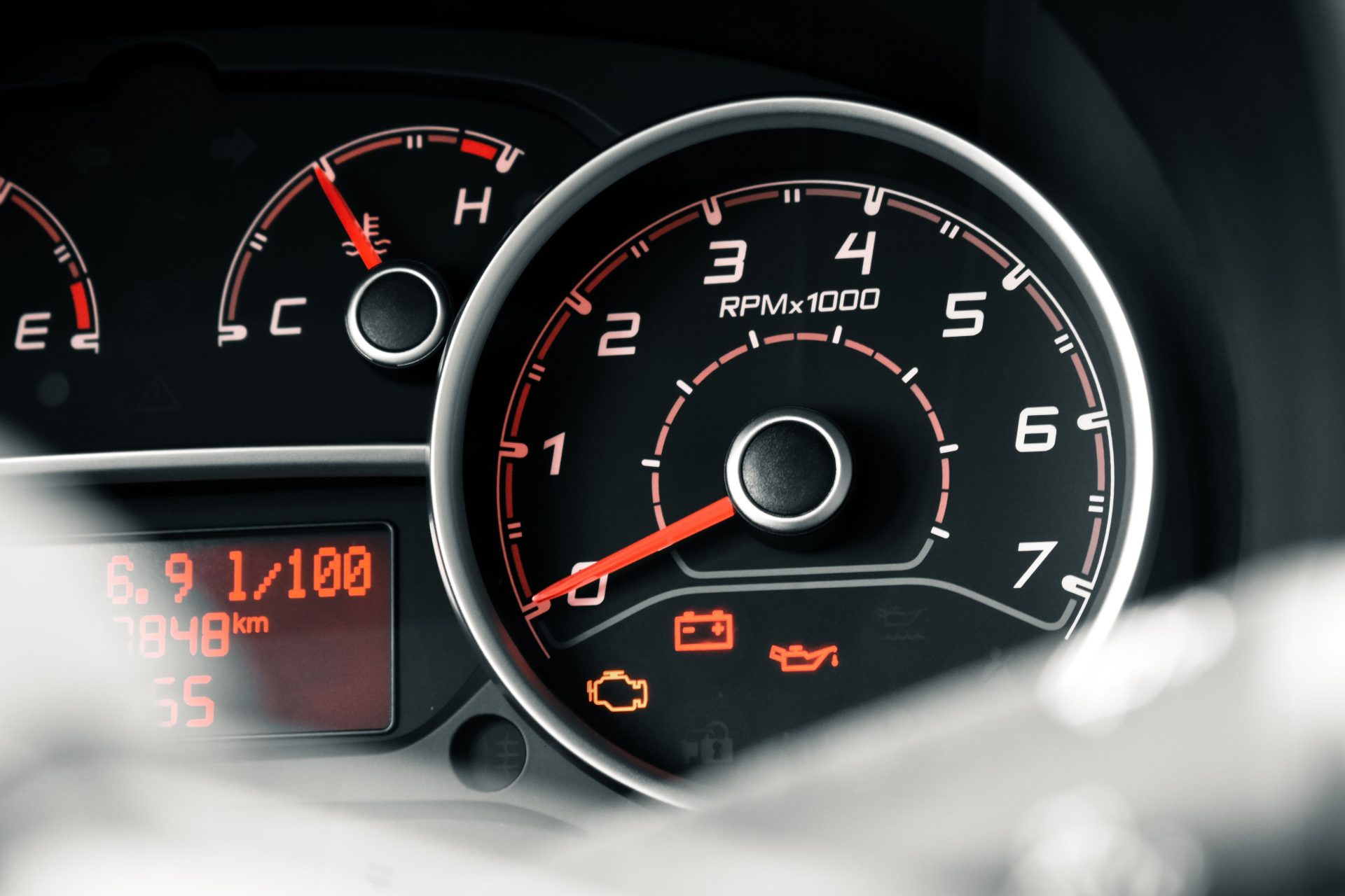 Detailed view of a car dashboard featuring tachometer, odometer, and various indicators.